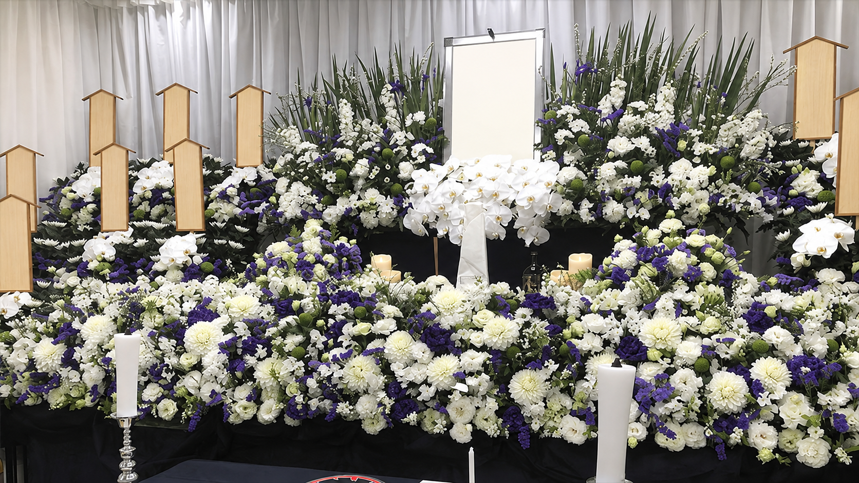 祭りのはっぴや思い出の品を飾り、白と紫の花で整えた実際のお葬式